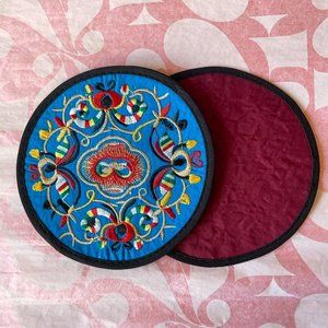 A pair of embroidered coasters